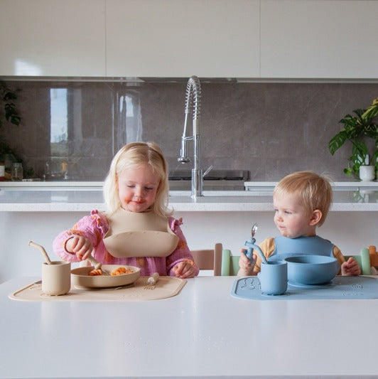 Babies eating with Zazi spoon wearing bib