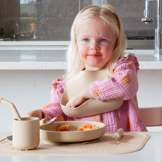 Baby eating with Zazi spoon wearing bib