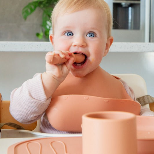 Baby boy eating wearing Zazi bpa-free silicone bib
