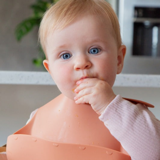Baby boy eating wearing Zazi bpa-free silicone bib